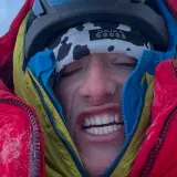 Balin Miller, le visage crispé par le froid, emmitouflé dans sa doudoune rouge et jaune, prêt pour l'aventure.