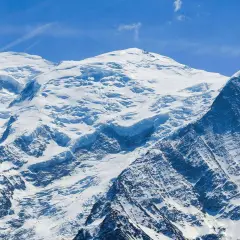 Majestueux Mont Blanc, son versant italien enneigé sous un ciel bleu éclatant. Un paysage alpin à couper le souffle.
