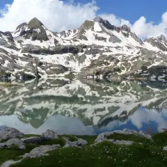 Reflets parfaits des montagnes enneigées dans l'ibon de Estanes. Un paysage d'une beauté saisissante.