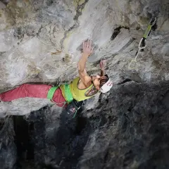 Angela Eiter, grimpeuse autrichienne, défie la gravité sur une paroi rocheuse. Sa concentration est palpable.