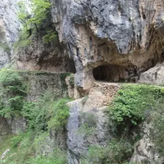 Sentier creusé dans la roche, le long de la ruta del Cares dans les Picos de Europa. Un tunnel naturel s'ouvre sur le chemin.