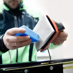 Un skieur prépare ses skis neufs. Il applique de la cire avec un fer chaud, une étape essentielle pour une glisse optimale.