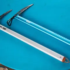 Deux piolets de montagne Petzl, un bleu et un argenté, prêts pour l'aventure.