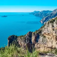 Randonnée sur la côte amalfitaine. Un randonneur admire la vue spectaculaire sur la mer bleue et les falaises escarpées.