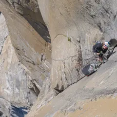 Soline Kentzel, grimpeuse audacieuse, évolue sur une paroi rocheuse vertigineuse, entourée de cordes et de matériel d'escalade.