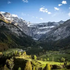 Vue spectaculaire du cirque de Gavarnie, avec ses montagnes imposantes, sa cascade et sa forêt verdoyante. La ruta circo de Gavarnie offre un panorama à couper le souffle.