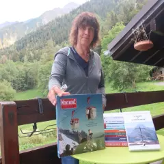 Catherine Destivelle aujourd'hui, fière de présenter des livres sur la montagne, dans un cadre verdoyant.