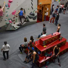 Des grimpeurs s'entraînent dans une salle de bloc, atteignant le **hueco zenith** sur des murs colorés.