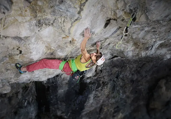 Angela Eiter, grimpeuse autrichienne, défie la gravité sur une paroi rocheuse. Sa concentration est palpable.