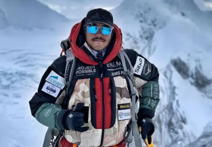 Nims Dai, alpiniste audacieux, porte sa veste "Project Possible" sur les sommets enneigés.