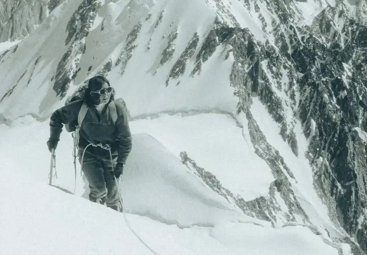Un alpiniste progresse sur une pente enneigée, crampons aux pieds. Une scène digne d'un podcast alpinisme.
