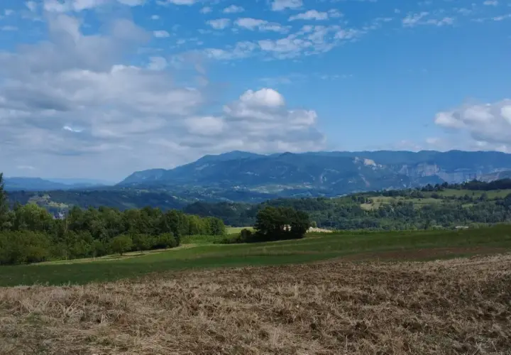 Paysage de montagnes bleues sous un ciel nuageux, parfait pour une randonnée près d'un pont en Royans.