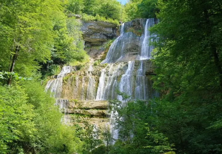 Magnifique cascade en escalier, parfaite pour une randonnée des cascades. L'eau dévale la roche, entourée d'une végétation luxuriante.