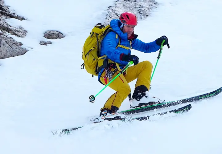 Davo Karnicar, skieur alpin, dévale une pente enneigée, bâtons de ski en main, prêt pour l'aventure.