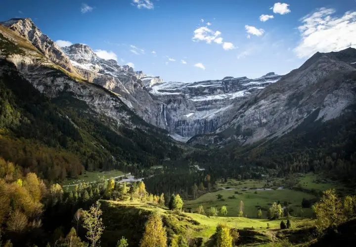 Vue spectaculaire du cirque de Gavarnie, avec ses montagnes imposantes, sa cascade et sa forêt verdoyante. La ruta circo de Gavarnie offre un panorama à couper le souffle.