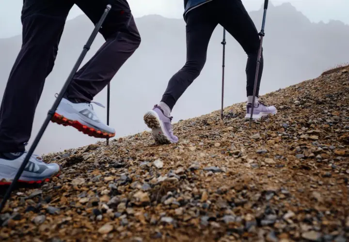 Randonneurs en montée, leurs chaussures de trail avec semelle de propreté assurant l'adhérence sur terrain rocailleux.