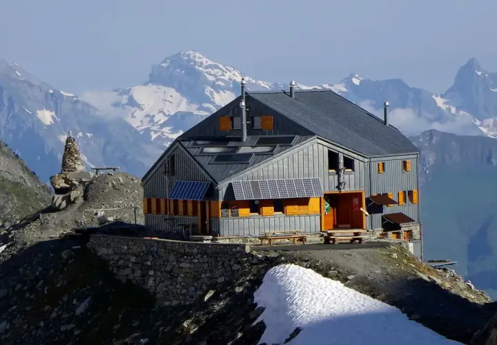 Refuge moderne sur fond de montagnes enneigées, un point de départ idéal pour le tour du Grand Combin. Panneaux solaires sur le toit.