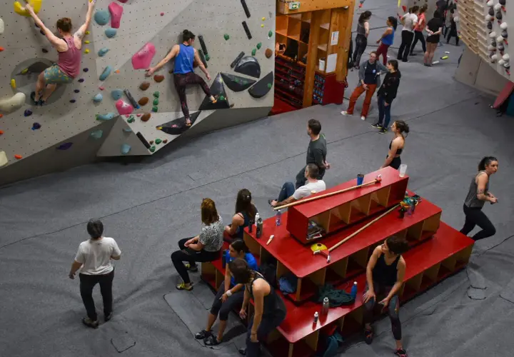 Des grimpeurs s'entraînent dans une salle de bloc, atteignant le **hueco zenith** sur des murs colorés.