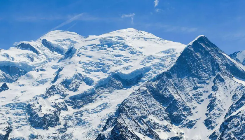 Majestueux Mont Blanc, son versant italien enneigé sous un ciel bleu éclatant. Un paysage alpin à couper le souffle.