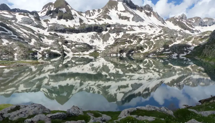 Reflets parfaits des montagnes enneigées dans l'ibon de Estanes. Un paysage d'une beauté saisissante.