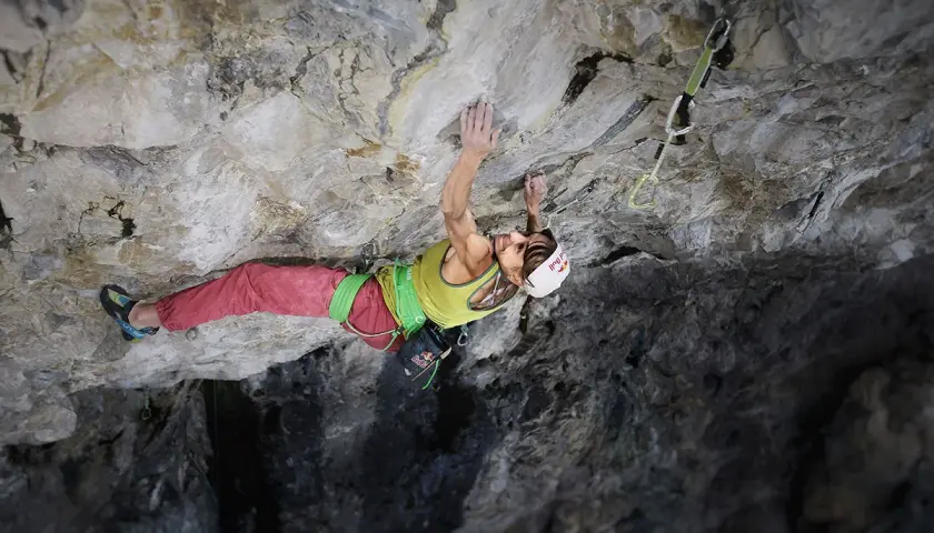 Angela Eiter, grimpeuse autrichienne, défie la gravité sur une paroi rocheuse. Sa concentration est palpable.