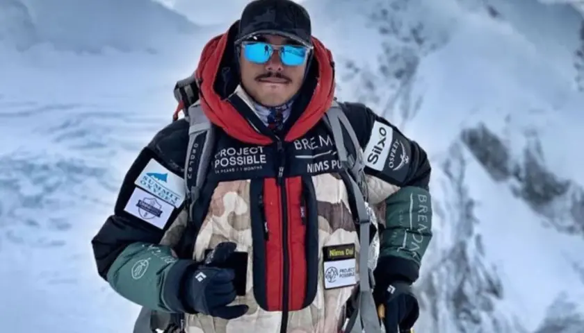 Nims Dai, alpiniste audacieux, porte sa veste "Project Possible" sur les sommets enneigés.
