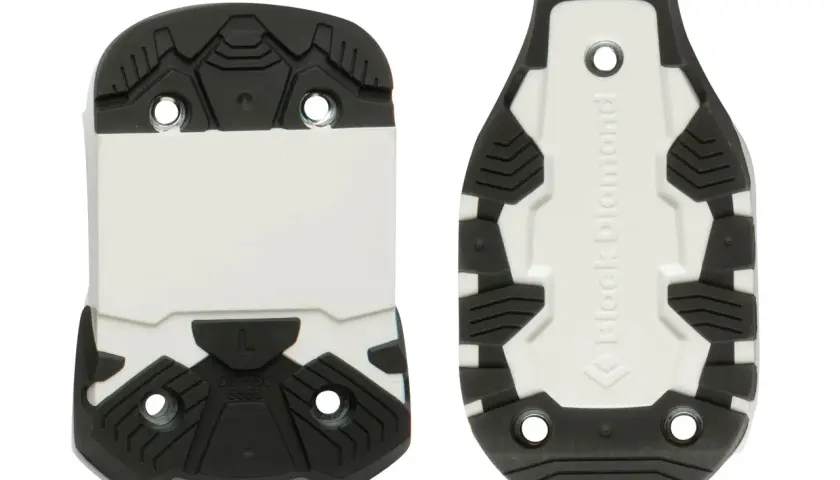 Semelles de ski alpin, conformes à la norme DIN-ISO 9523, avec crampons noirs et partie blanche.