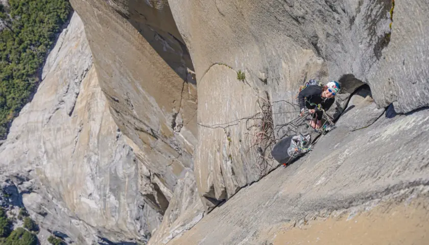 Soline Kentzel, grimpeuse audacieuse, évolue sur une paroi rocheuse vertigineuse, entourée de cordes et de matériel d'escalade.