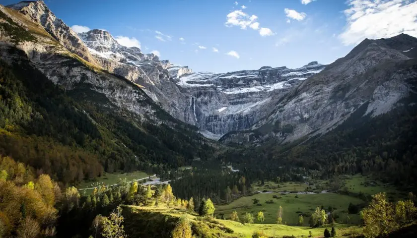 Vue spectaculaire du cirque de Gavarnie, avec ses montagnes imposantes, sa cascade et sa forêt verdoyante. La ruta circo de Gavarnie offre un panorama à couper le souffle.