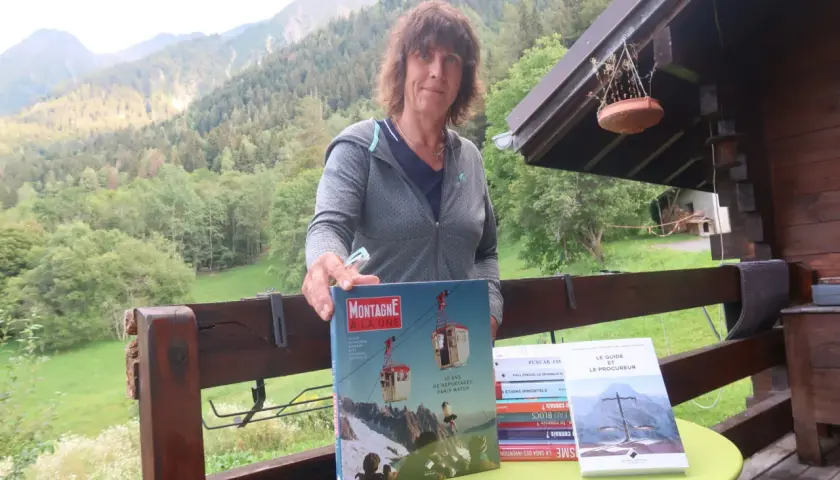 Catherine Destivelle aujourd'hui, fière de présenter des livres sur la montagne, dans un cadre verdoyant.