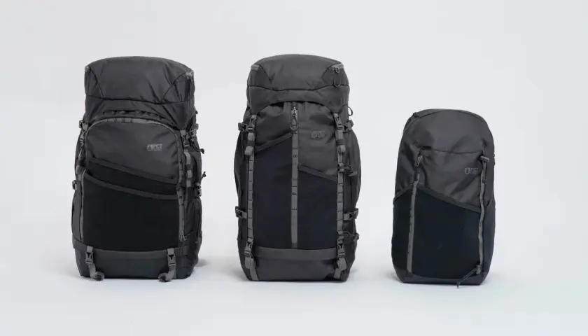 Trois sacs à dos noirs de différentes tailles, prêts pour faire son sac de randonnée.