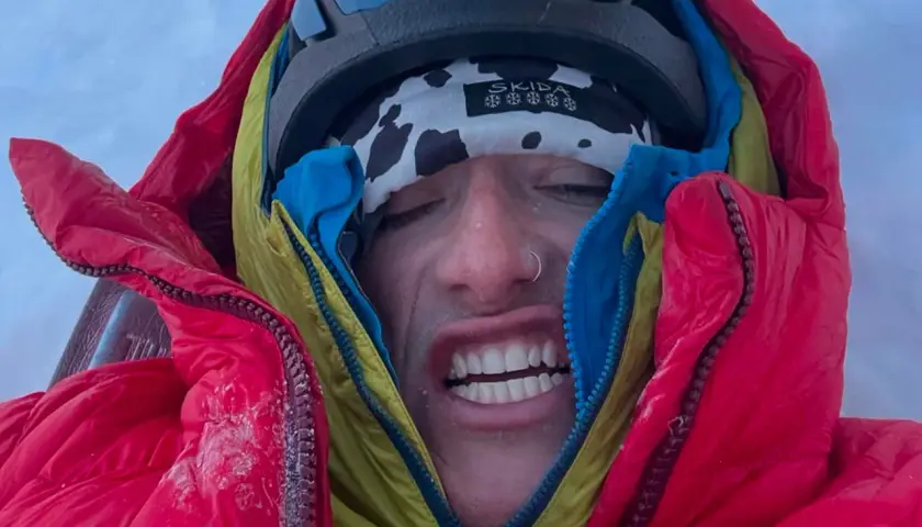 Balin Miller, le visage crispé par le froid, emmitouflé dans sa doudoune rouge et jaune, prêt pour l'aventure.
