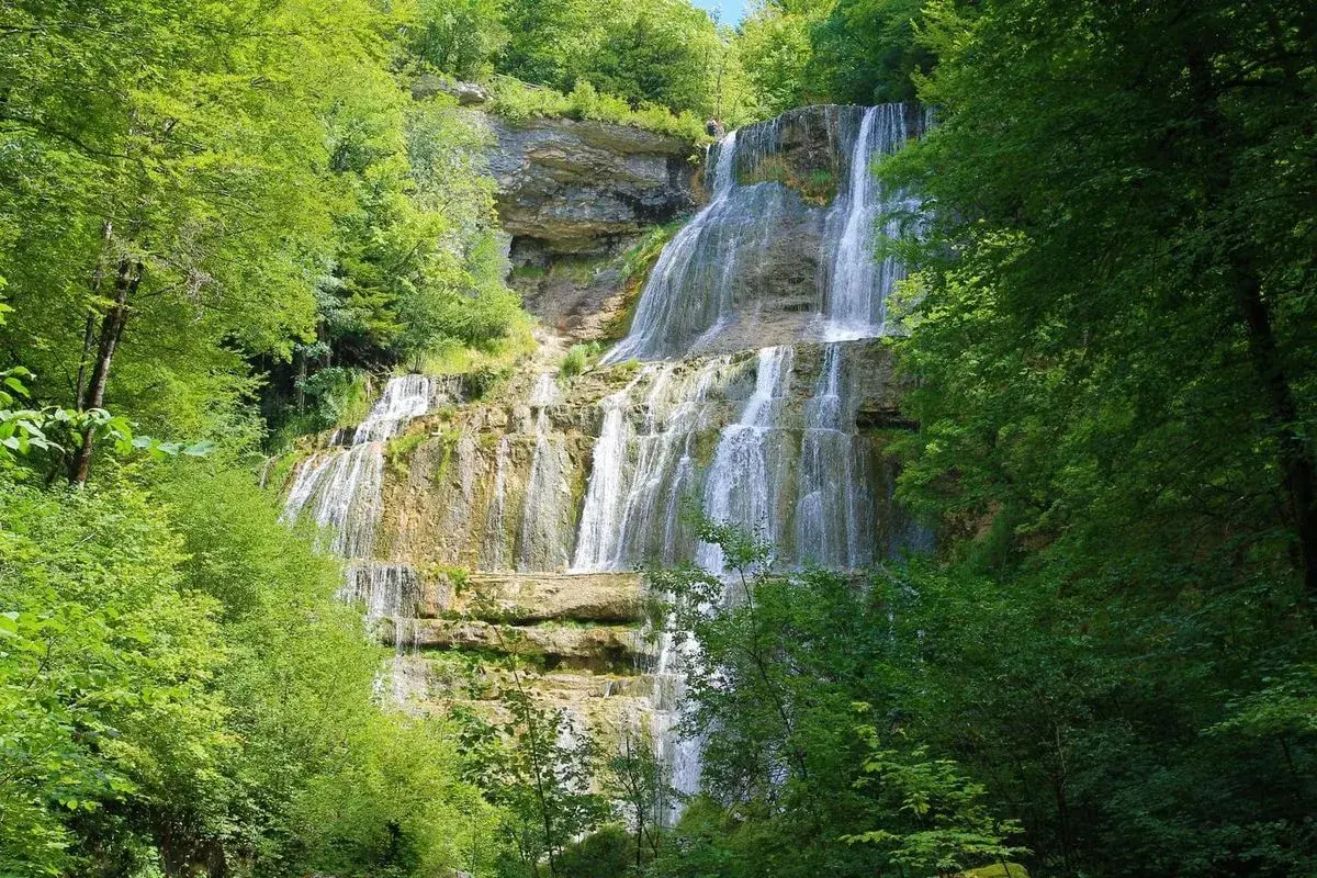 Magnifique cascade en escalier, parfaite pour une randonnée des cascades. L'eau dévale la roche, entourée d'une végétation luxuriante.