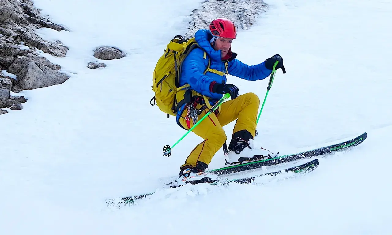 Davo Karnicar, skieur alpin, dévale une pente enneigée, bâtons de ski en main, prêt pour l'aventure.