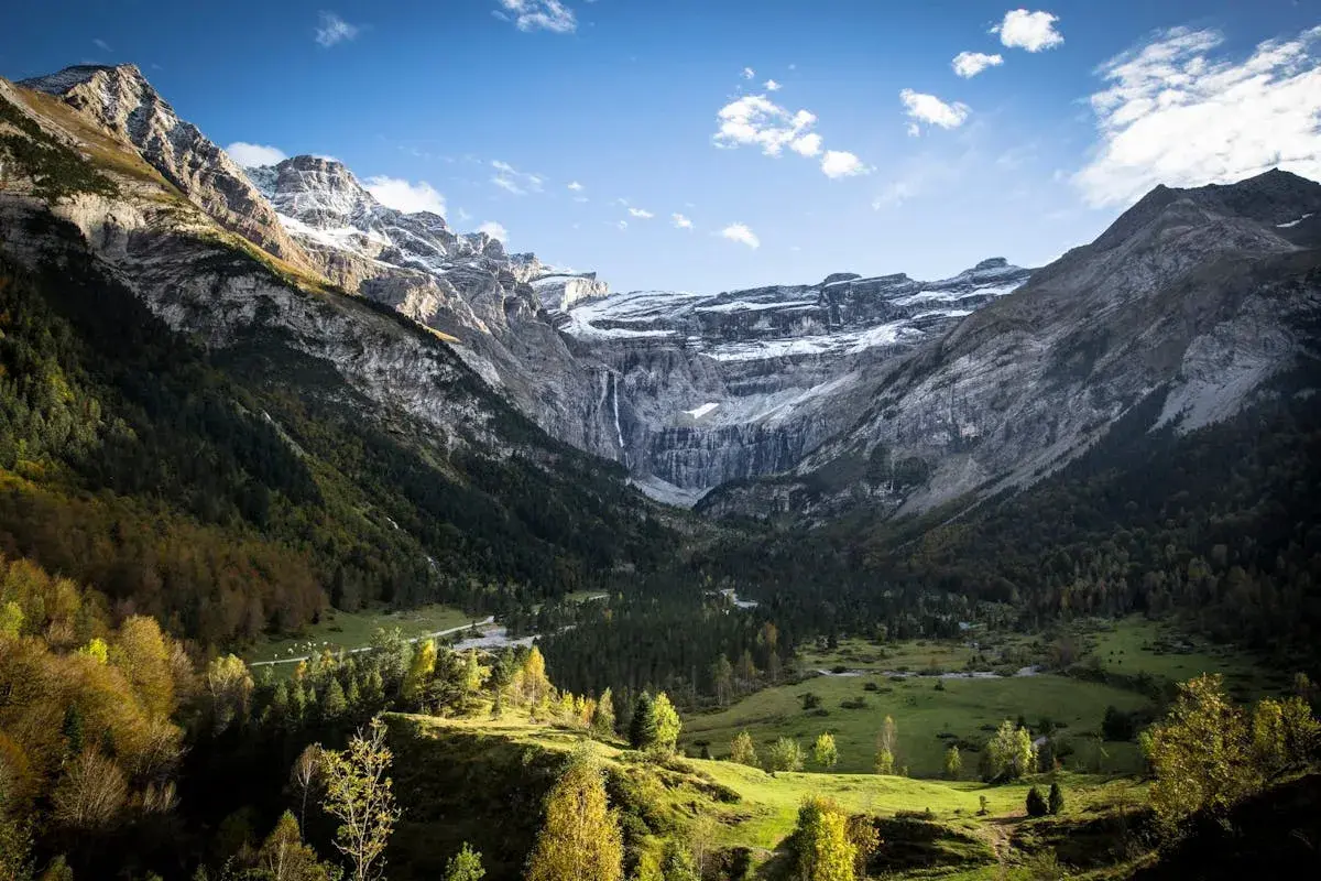 Vue spectaculaire du cirque de Gavarnie, avec ses montagnes imposantes, sa cascade et sa forêt verdoyante. La ruta circo de Gavarnie offre un panorama à couper le souffle.