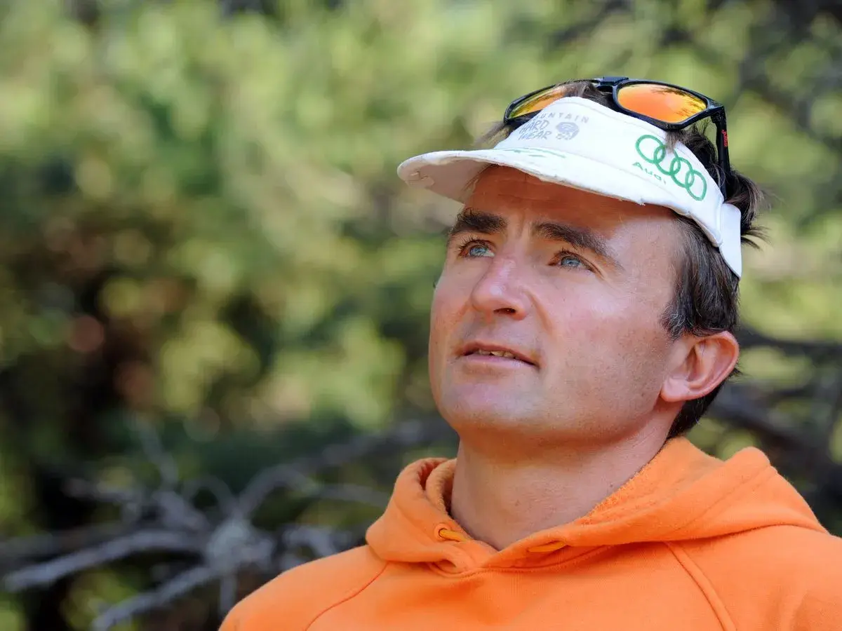 Portrait d'Ueli Steck, le célèbre alpiniste, avant son tragique accident. Il porte une casquette et un sweat orange.