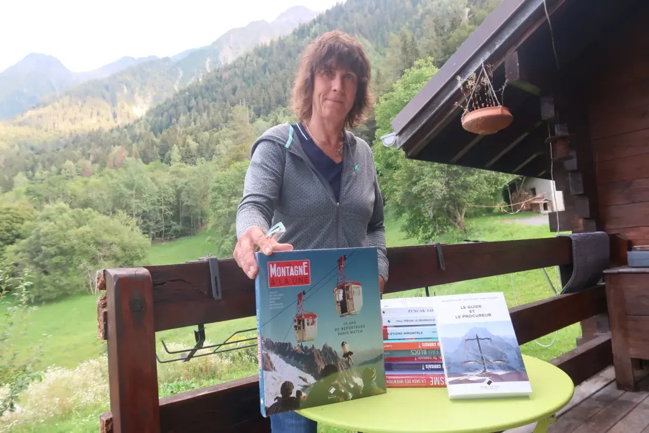 Catherine Destivelle aujourd'hui, fière de présenter des livres sur la montagne, dans un cadre verdoyant.
