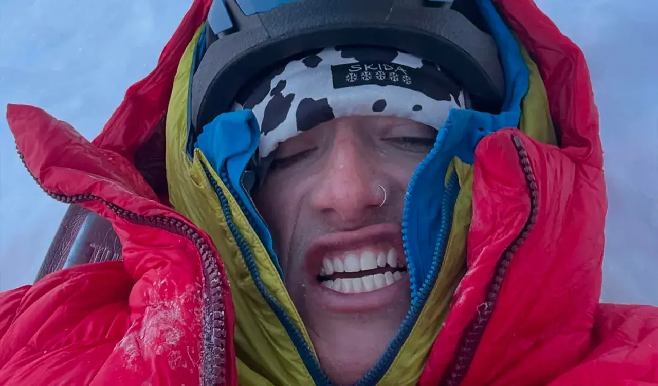 Balin Miller, le visage crispé par le froid, emmitouflé dans sa doudoune rouge et jaune, prêt pour l'aventure.