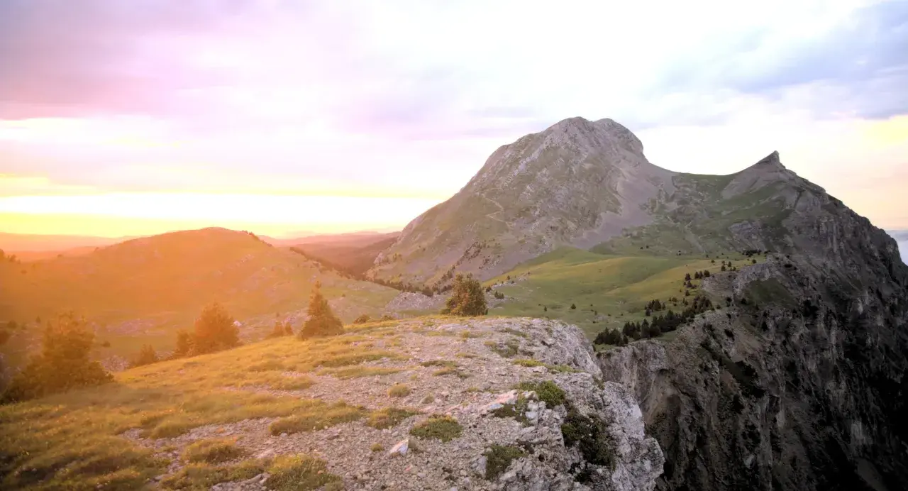 Le soleil couchant embrase les contreforts verdoyants menant au point culminant du Vercors. Un paysage spectaculaire.