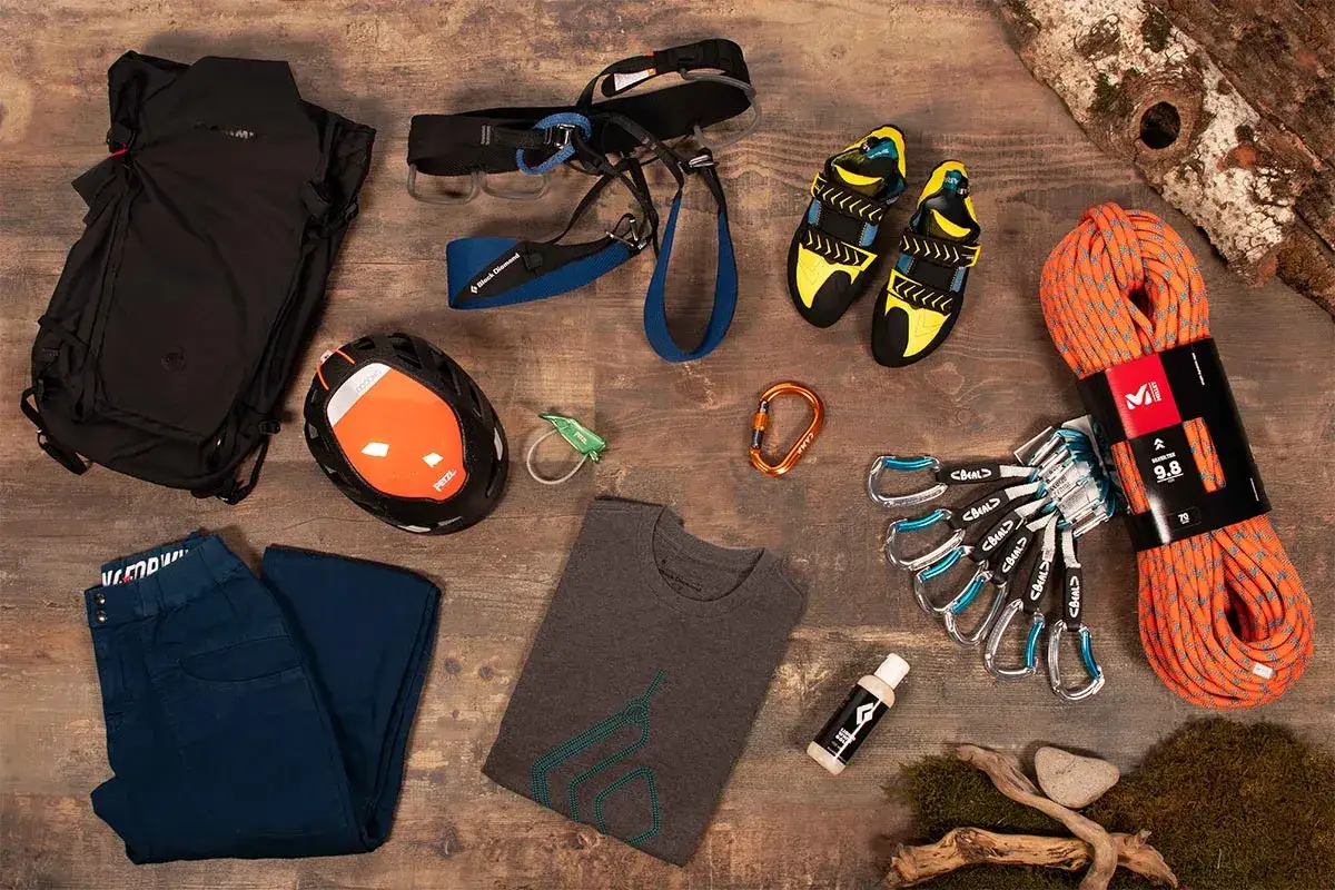 Matériel pour l'escalade outdoor : baudrier, chaussons, casque, corde, mousquetons, sac à dos et pantalon.