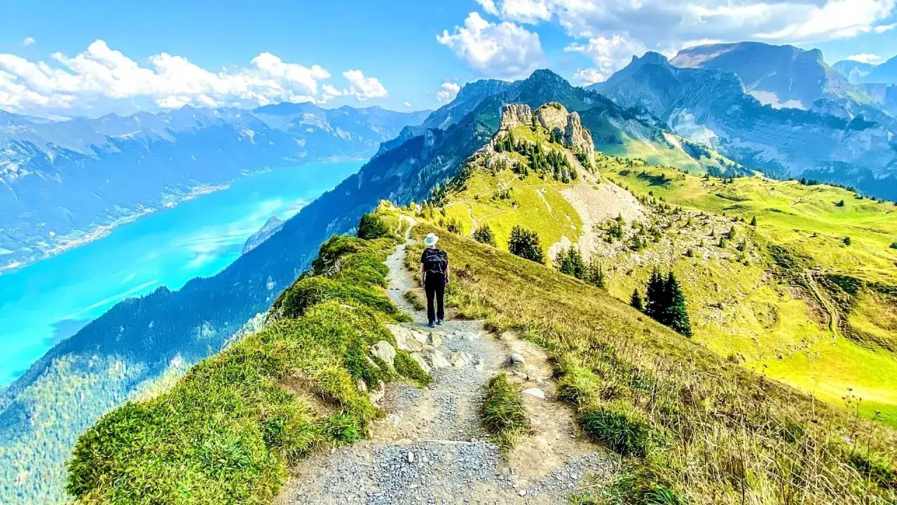 Randonn&eacute;e sur un sentier escarp&eacute; avec vue sur le lac et les montagnes de l'Eiger Jungfrau.