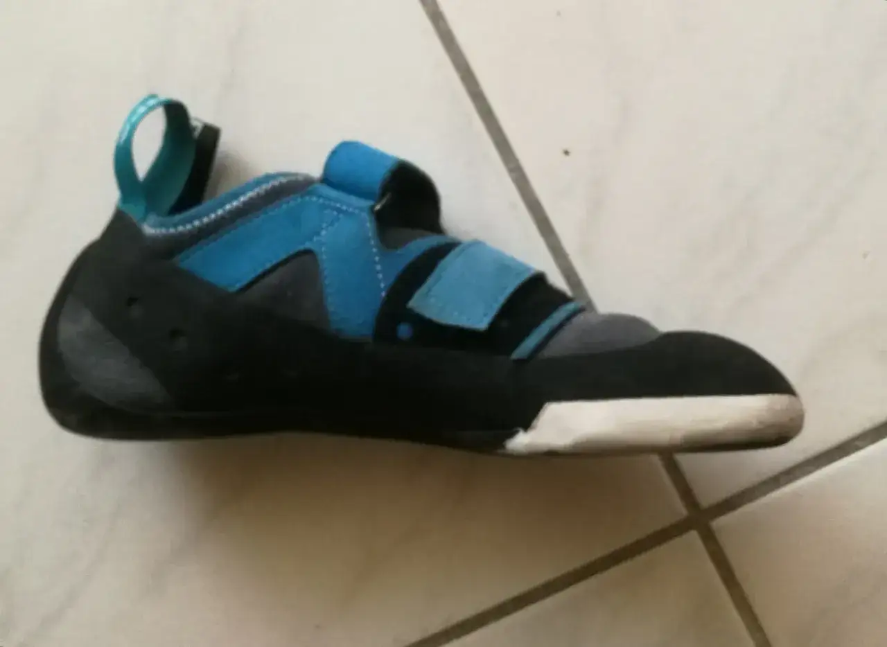 Chausson d'escalade bleu et noir, prêt à conquérir les parois. Sa semelle adhérente promet une excellente prise.