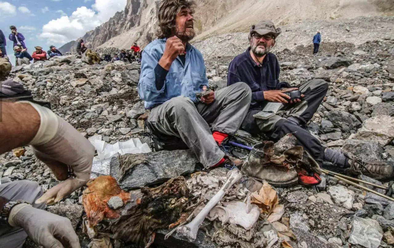 Reinhold Messner, entouré de restes, semble réfléchir à un mensonge sur cette montagne rocailleuse.