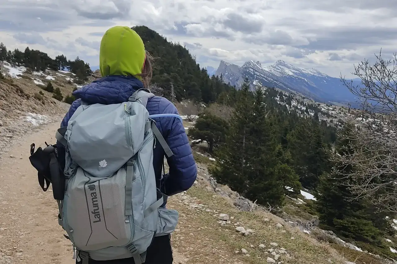 Randonneur avec un sac à dos Lafuma, prêt à explorer les montagnes enneigées. Les vêtements Lafuma sont parfaits pour l'aventure.