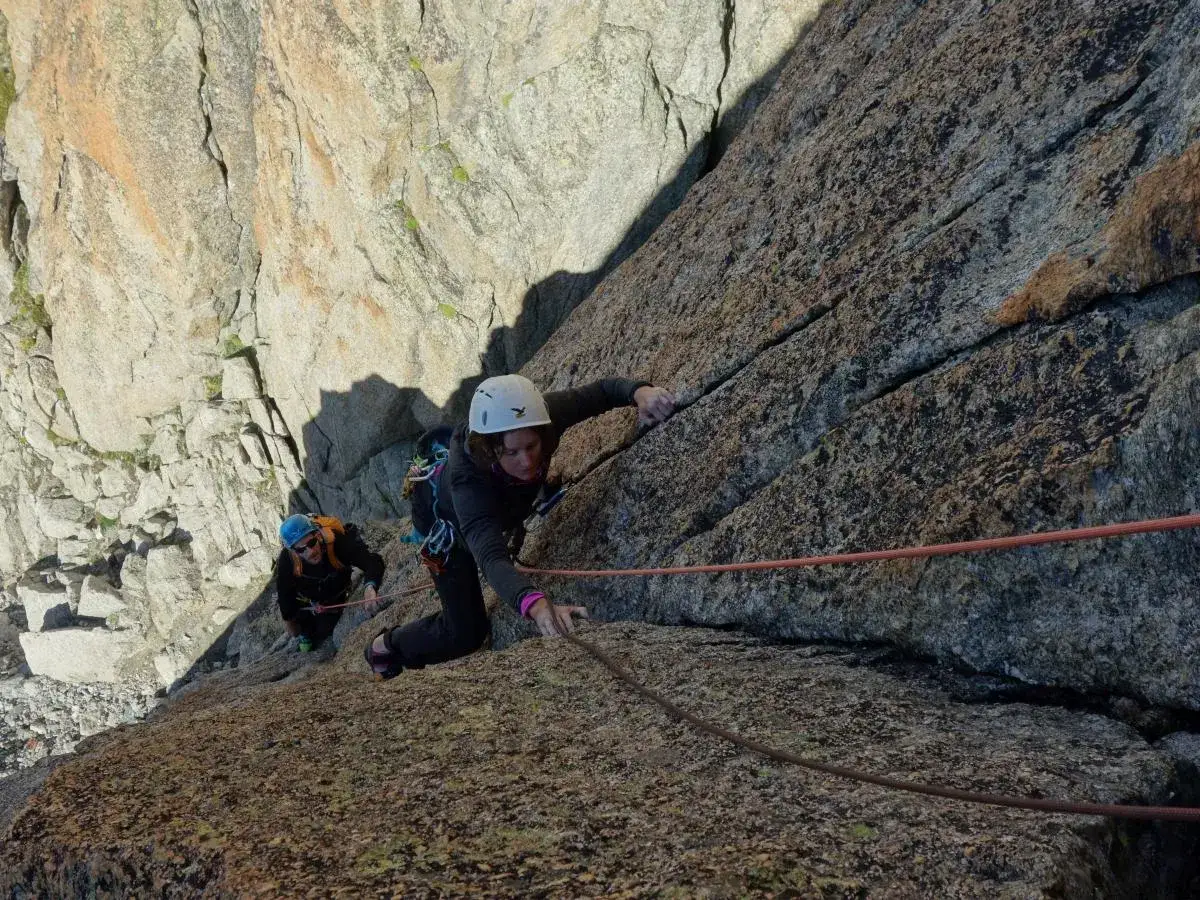 Deux alpinistes escaladent une paroi rocheuse abrupte, d&eacute;fiant les hauteurs vertigineuses des blocs des Alpes.