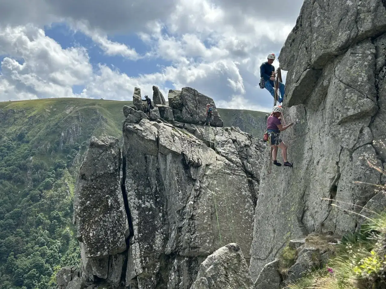 Escalade dans le Red River Gorge, des grimpeurs s'attaquent &agrave; des falaises rocheuses sous un ciel nuageux.